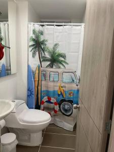 un bagno con un water e una tenda da doccia con un furgone di Acogedor Apart piscina, descanso y teletrabajo a Ricaurte