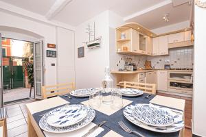 uma cozinha com uma mesa com pratos em CoZy House Boccadasse by the sea in Genova em Gênova