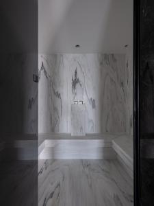 Cette chambre est dotée d'un mur en marbre et d'une fenêtre. dans l'établissement The Tanneries Hotel & Spa, à La Canée