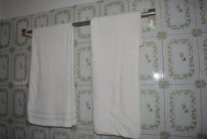 two white towels hanging on a towel rack in a bathroom at Chez Sabine in Abomey +36 photos