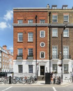 倫敦的住宿－Luxury 1-bedroom apartment in Marylebone，一座大型砖砌建筑,前面停放着自行车