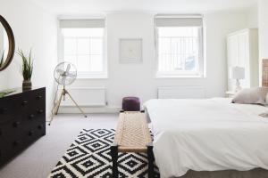 a white bedroom with a bed and a fan at Luxury 1-bedroom apartment in Marylebone in London