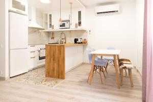 a kitchen with white cabinets and a table and chairs at Spiral Stairs Duplex in Figueres