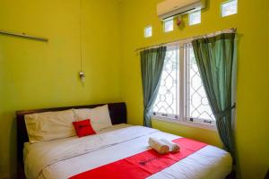 a small bedroom with a bed with a window at RedDoorz near Institut Pertanian Yogyakarta in Yogyakarta