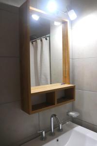 un bagno con lavandino e specchio di EDIFICIO CABO FRIO a Pinamar