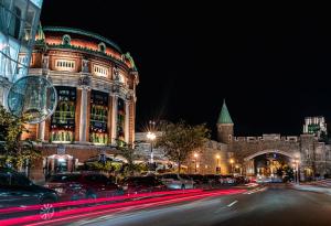 a city street at night with a large building at Le Capitole Hotel in Quebec City