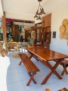 - une salle à manger avec une table et des chaises en bois dans l'établissement Flats Villa Gelú, à Barra Grande