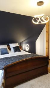 a bedroom with a large bed with a black wall at Chambre d'hôtes Le Lavandin in Kleingoeft