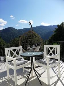 2 sillas y una mesa con copas de vino en el patio en Apartma Neža en Bled