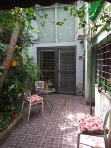 een patio met 2 stoelen, een tafel en een raam bij Jardin Secreto in Rosario