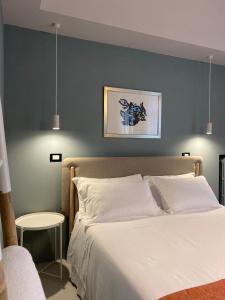 1 dormitorio con 1 cama con pared azul en Casimiro Rooms, en Cesena