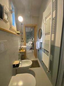 a bathroom with a white toilet and a sink at Casimiro Rooms in Cesena