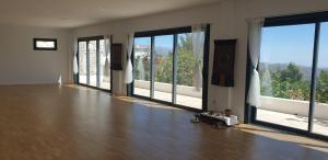an empty room with large windows and a wooden floor at Las Chimeneas in Mairena