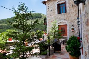 a patio with a table and a tree in front of a building at Amanites Guesthouse in Dimitsana