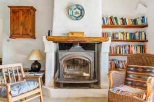 a living room with a fireplace and a chair at Las Chimeneas in Mairena