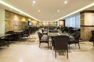 فندق ابريز في جدة: مطعم فيه طاولات وكراسي في الغرفة