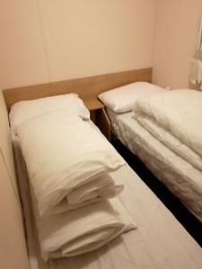 two beds in a room with white pillows at 707 Seawick in Jaywick Sands