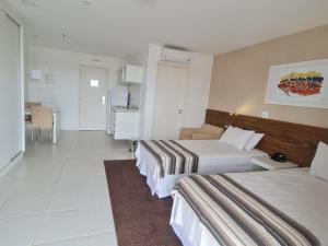 a hotel room with two beds and a table at Flat Particular - SHN - Vista Livre Esplanada in Brasilia