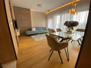 - un salon avec une table en verre et un canapé dans l'établissement Exclusive BL apartments, à Banja Luka