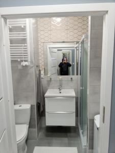 mężczyzna robiący zdjęcie w lustrze w łazience w obiekcie Róża- Lotnisko we Wrocławiu