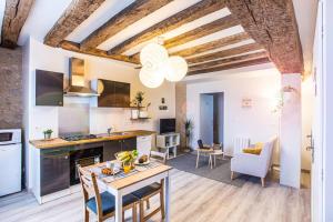 cocina y sala de estar con paredes blancas y techos de madera. en LE VINCI Échappée Amboisienne avec sauna partagé, en Amboise