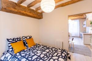 1 dormitorio con cama extragrande y almohadas amarillas en LE VINCI Échappée Amboisienne avec sauna partagé, en Amboise