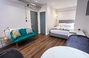 Three Cranes Serviced Apartments في شيفيلد: غرفة معيشة مع سرير وأريكة وطاولة