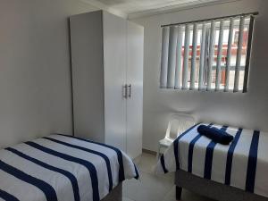 a white bedroom with a bed and a window at Covenant Place in Cape Town