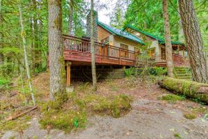 a house with a large deck in the woods at Papa Bear Cabin in Welches