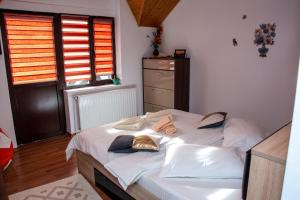 a bedroom with a bed with white sheets and pillows at Casa Albert Sinaia in Sinaia