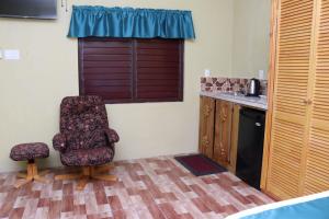 a kitchen with a chair and a counter and a window at Eliwes Villa in Treasure Beach
