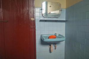 a bathroom with a blue sink and a mirror at Hotel Olibert Parapat Ajibata Mitra RedDoorz in Parapat