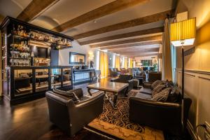 a bar with leather chairs and a table in a room at Relais Villa D'Amelia in Benevello