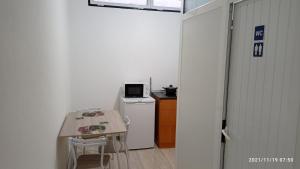 a small kitchen with a table and a refrigerator at Cantinho dos Remédios in Lajes