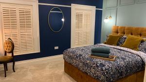 a bedroom with a bed with a mirror and a chair at ENAS COVE Homely Getaway in Derry Londonderry