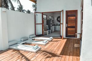 a room with two beds on a wooden deck at Boutique Lux Villa in Jambiani