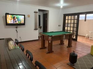 a room with a pool table and a tv at Hotel Praia Bonita in Capão da Canoa