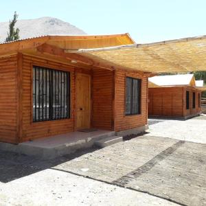 ein Holzgebäude mit einem Außentor in der Unterkunft Cabañas Rivadavia Spa in Vicuña