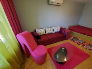 a living room with a couch and a pink chair at Свежест и Уют Център Безплатен Паркинг Релакс in Plovdiv