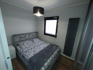 Schlafzimmer mit einem Bett und einem Fenster in der Unterkunft Apartament Chmielna - Waterlane Island in Danzig