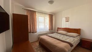 a bedroom with a bed and a window at Prime Apartments in Bansko