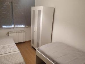 a bedroom with two beds and a white cabinet at Apartamento CUATTRO vut 47-169 wifi in Valladolid