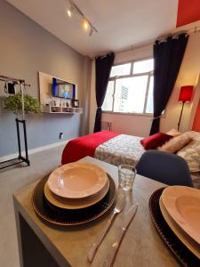 ein Raum mit einem Tisch mit Tellern darauf in der Unterkunft GUARALOFT TOKYO Centro de Guarapari in Guarapari