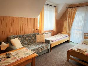 a living room with a couch and a bed at Pokoje Gościnne "U Elżbiety" 2 in Małe Ciche