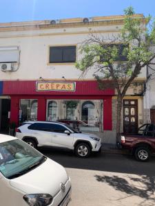 a white car parked in front of a crepes restaurant at Los Naranjeles Centro House in Salto