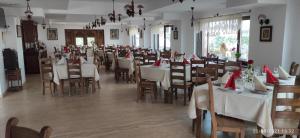 ein Esszimmer mit Tischen und Stühlen mit roten Servietten in der Unterkunft Complex Transalpina in Aninişu din Vale