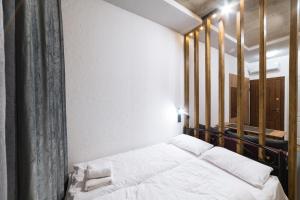 1 dormitorio con cama blanca y ventana en Нові смарт-квартири з парком і набережною!, en Uzhhorod