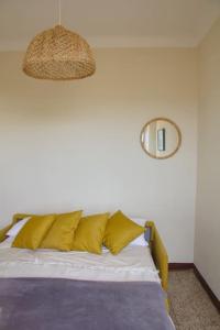 ein Schlafzimmer mit einem Bett mit gelben Kissen in der Unterkunft Casa Paz, centro storico vista mare in Bordighera