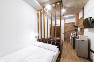 1 dormitorio con 1 cama blanca y cocina en Нові смарт-квартири з парком і набережною!, en Uzhhorod