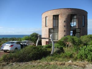 a building with a car parked in front of it at Casa Dos Milagres Holiday Home in Agulhas